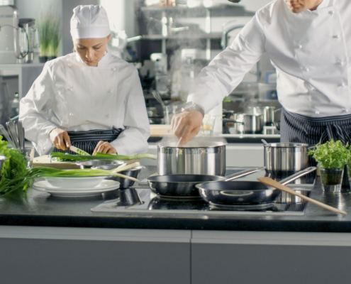 Two chefs in kitchen preparing food on food safe floors