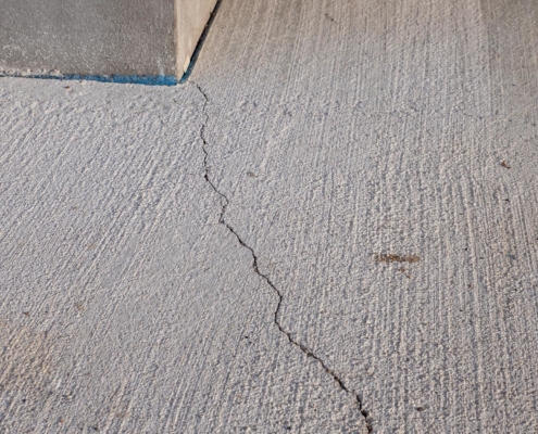 Close-up view of cracked concrete flooring in warehouse