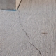 Close-up view of cracked concrete flooring in warehouse